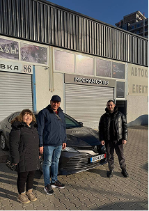 Happy customers next to imported car